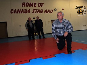 Jeff Ducharme, front, vice president of CUPE Local 27, gets a good look at the old gym floor at Sandwich Teen Action Group, after hs union made a generous $2,500 donation toward a new floor Wednesday Dec. 2, 2015. With 350 members at STAG, the gymnasium receives heavy use, especially for basketball.