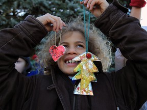 General Brock Public School student Taras Washington-Janusas prepares to add his decoration to the Sandwich Community Christmas Tree at Mackenzie Hall Wednesday December 02, 2015. Classes from Brock also enjoyed a hot dog and hot chocolate while taking turns attaching their handmade decorations. Students created their own decorations to make the tree look special for this yearÕs Santa Claus Parade and the festive season, with the help of a generous donation of supplies from Monarch Basics.