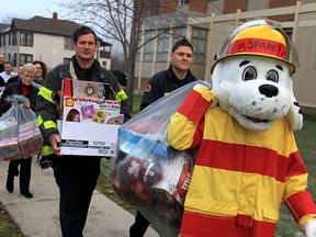 Windsor firefighters Matt Stephenson and James Szlatoszlavek were joined by Sparky at Mason Education Centre where 30 staff and faculty donated about $5000 of toys for the annual Sparky's Toy Drive, Monday Dec. 7, 2015.  It was the 15th year Mason employees contributed with generous donations.