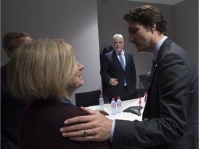 Quebec Premier Philippe Couillard and B.C. Premier Christy Clark and Saskatchewan Premier Brad Wall (hidden) wait to greet Canadian Prime Minister Justin Trudeau as he speaks with Alberta Premier Rachel Notley before a meeting with Canadian premiers at the United Nations climate change summit, Monday November 30, 2015 in Le Bourget, France. THE CANADIAN PRESS/Adrian Wyld