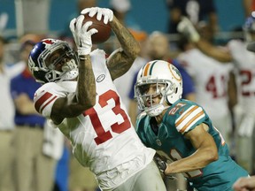 New York Giants wide receiver Odell Beckham (13) makes a catch as Miami Dolphins cornerback Brent Grimes (21) defends, during the first half of an NFL football game, Monday, Dec. 14, 2015, in Miami Gardens, Fla.  (AP Photo/Wilfredo Lee)