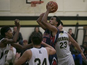Holy Names' Isaiah Familia, centre, takes a shot in the key while being surrounded by Riverside defenders during WECSSA boys basketball between the Riverside Rebels and the visiting Holy Names Knights, Monday, December 14, 2015.  (DAX MELMER/The Windsor Star)