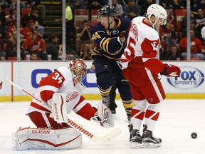 Detroit Red Wings center Riley Sheahan (15) blocks a shot as Buffalo Sabres left wing Nicolas Deslauriers (44) jumps in front of goalie Petr Mrazek (34) in the first period of an NHL hockey game Monday, Dec. 14, 2015 in Detroit. (AP Photo/Paul Sancya)