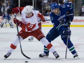 Detroit Red Wings' Dylan Larkin, left, takes the puck away from Vancouver Canucks' Radim Vrbata, of the Czech Republic, during the first period of an NHL hockey game in Vancouver, B.C., on Saturday October 24, 2015. THE CANADIAN PRESS/Darryl Dyck