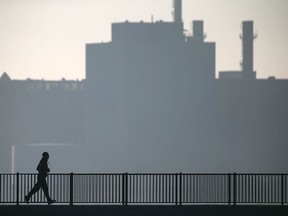 Dan Balcomb is silhouetted against a hazy Mistersky Power Station in Detroit while enjoying a run along the Detroit River on a balmy Sunday afternoon, Dec. 6, 2015. (DAX MELMER/The Windsor Star)