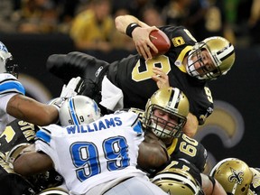 Drew Brees #9 of the New Orleans Saints dives on a quaterback sneak on fourth down in the third quarter against Corey Williams #99 of the Detroit Lions during their 2012 NFC Wild Card Playoff game at Mercedes-Benz Superdome on January 7, 2012 in New Orleans, Louisiana.  (Photo by Ronald Martinez/Getty Images)