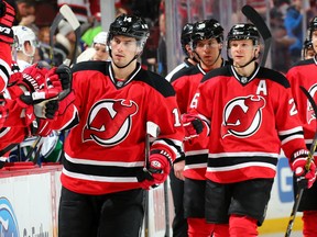 Adam Henrique #14 and Patrik Elias #26 of the New Jersey Devils celebrate Elias' goal with teammates on the bench in the first period against the Vancouver Canucks on February 20, 2015 at the Prudential Center in Newark, New Jersey.  (Photo by Elsa/Getty Images)