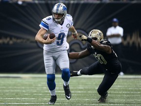 Matthew Stafford #9 of the Detroit Lions avoids a tackle by Stephone Anthony #50 of the New Orleans Saints during the first quarter of a game at the Mercedes-Benz Superdome on December 21, 2015 in New Orleans, Louisiana.  (Photo by Chris Graythen/Getty Images)