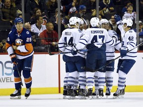 Toronto Maple Leafs defenseman Morgan Rielly (44), center Leo Komarov (47) and  center Tyler Bozak (42) celebrate right wing Michael Grabner's goal with teammates as New York Islanders center Brock Nelson (29) reacts during the second period of an NHL hockey game on Sunday, Dec. 27, 2015, in New York. (AP Photo/Kathy Kmonicek)