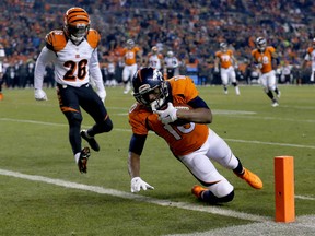 Denver Broncos wide receiver Emmanuel Sanders (10) scores a touchdown as Cincinnati Bengals cornerback Josh Shaw (26) defends during the first half of an NFL football game, Monday, Dec. 28, 2015, in Denver. (AP Photo/Jack Dempsey)