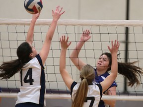 Breanna Lewis Parent (R) of Assumption spikes a ball by Emma Bedal (L) and Robyn Jadischke during their game on Tuesday, December 1, 2015, in Windsor, ON. (DAN JANISSE/The Windsor Star)