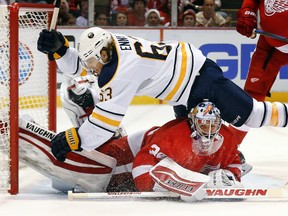 Buffalo Sabres left wing Tyler Ennis (63) crashes into Detroit Red Wings goalie Petr Mrazek (34) in the first period during an NHL hockey game in Detroit, Tuesday, Dec. 23, 2014. (AP Photo/Paul Sancya)