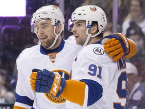 New York Islanders' John Tavares, right, celebrates with teammate Calvin de Haan after scoring his team's second goal against the Toronto Maple Leafs during first period NHL hockey action, in Toronto, on Tuesday, December 29, 2015. THE CANADIAN PRESS/Chris Young