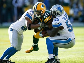 Randall Cobb #18 of the Green Bay Packers is tackled by  Josh Wilson #30 and Stephen Tulloch #55 of the Detroit Lions in the second quarter at Lambeau Field on November 15, 2015 in Green Bay, Wisconsin.  The Detroit Lions defeat the Green Bay Packers 18 to 16. (Photo by Joe Robbins/Getty Images)