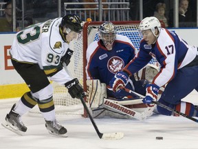 Windsor Spitfires defenceman Logan Stanley dives as he tries to keep London Knights forward Mitch Marner from reaching a loose puck in front of Spitfires goaltender Garret Hughson during their OHL hockey game at Budweiser Gardens in London, Ont. on Friday December 4, 2015. Craig Glover/The London Free Press/Postmedia Network