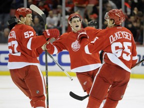 Detroit Red Wings defenseman Jonathan Ericsson (52) of Sweden, and center Dylan Larkin (71), middle, congratulate defenseman Danny DeKeyser (65) after DeKeyser scores against the Arizona Coyotes during the second period of an NHL hockey game in Detroit, Thursday, Dec. 3, 2015.