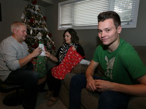 Spits defenceman Mikhail (Misha) Sergachev, right, relaxes with Michelle and Brian Reid in Tecumseh. (NICK BRANCACCIO/Windsor Star)
