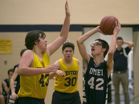 UMEI's J.R. Warkentin takes a shot while being defended by Western's Michael Dupuis in high school boys basketball between Western Secondary School and UMEI Christian High School, Wednesday, Dec. 16, 2015.