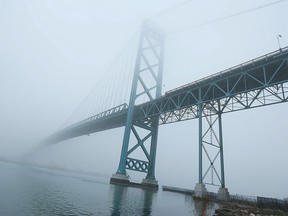 The Ambassador Bridge disappears into the fog over the Detroit River in Windsor, Ont. on Monday, Dec. 7, 2015.