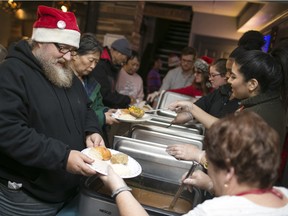 Volunteers serve up a free Christmas dinner at The Foundry Pub, Friday, December 25, 2015.