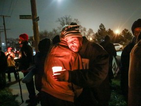 Clarence Strickland, father of Xavier Strickland, gets a hug during the candlelight vigil for Xavier Strickland on Saturday, Dec. 5, 2015, in Detroit. The 4-year-old Detroit boy who was mauled to death by pit bulls. Xavier Strickland and her son were walking to a school when the attack occurred. (Kimberly P. Mitchell/Detroit Free Press via AP)  DETROIT NEWS OUT; TV OUT; MAGS OUT; NO SALES; MANDATORY CREDIT DETROIT FREE PRESS