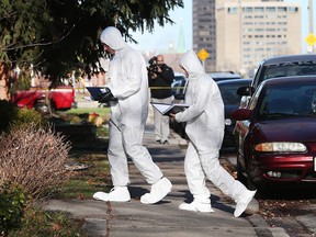 Windsor police forensics officers clad in overalls prepare to enter the residence at 187 Oak St. on Dec. 24, 2015.