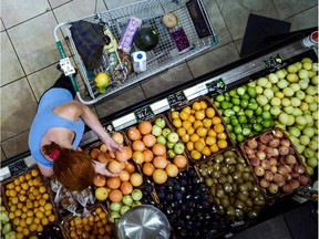 A shopper picks through fruit in the produce section at a supermarket.