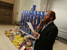 WINDSOR, ON. DECEMBER 7, 2015. -- Rabibi Sholom Galperin leads a Chanukah celebration at the Devonshire Mall in Windsor on Monday, December 7, 2015. In addition to the lighting of the menorah a mac-a-norah was created with rice, beans and pasta. The food which was collected will be donated to the Unemployment Help Centre.
