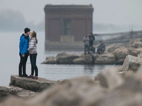 A couple stops for a kiss along the riverfront on Saturday, Dec. 12, 2015. The area is enjoying spring-like weather as temperatures hit a high of 15 C on Saturday.