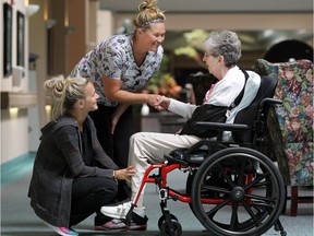 Chartwell Leamington  personal support workers, Melanie Groleau, and Melissa Branch spend time with long-term care resident Shirley Fobe in this July 13, 2015 file photo.