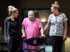 Chartwell Leamington Retirement Residence personal support workers, Melanie Groleau, and Melissa Branch walk with long-term care resident Nancy Hallett in this July 13, 2015 file photo.