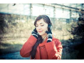 Listening to music with headphones in the park. Photo by fotolia.com