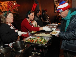 Volunteers Marybeth Martens (left) and Diane Lewicki serve up a Christmas meal at Chanoso's restaurant in Windsor in this 2014 file photo. The annual dinner attracted hundreds who were treated to a turkey dinner and desserts