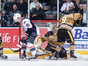 Windsor Spitfires forward Aaron Luchuk, left, fights for the puck with Sarnia centre Troy Lajeunesse, right, in front of Sting goalie Justin Fazio during OHL action Friday night in Sarnia. The Spitfires defeated the Sting 3-0.