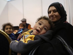 Syrian refugees wait at Marka Airport in Amman, Jordan, on Tuesday, Dec. 8, 2015 to complete their migration procedures to Canada, which has announced that it will take around 25,000 Syrians from Jordan, Lebanon and Turkey.