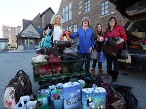 From left, Charmaine Gillis owner of  Ocean Bottom Soap company,  Mary-Jo Kovaks from the Downtown Mission, Veda Trepanier and Nurse Kim display more than 100 purses and man bags donated to the Downtown Mission on Dec. 24, 2015.