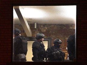 Windsor police ESU unit officers are shown through the window a Park Street apartment where a man was arrested after a standoff late Thursday evening.