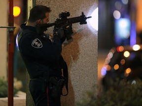 A Windsor police officer aims his gun at a Park Street apartment where a man was arrested after a standoff late Thursday evening.