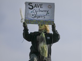 A woman holds a sign 'Save Ojibway Shores' while at the Windsor People's Climate March at the riverfront, Sunday, Nov. 29, 2015.