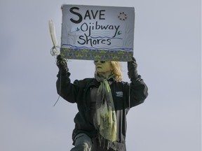 A woman holds a sign at the Windsor People's Climate March at the riverfront on Nov. 29, 2015.