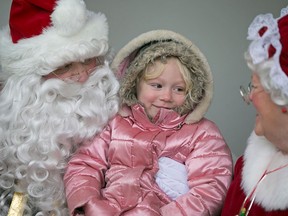 Lilliana Lemieux-Groulx, 4, visits with Santa Claus and Mrs. Claus during an event Sunday, Dec. 20, 2015, when 550 food baskets were handed out to those in need. Ten Windsor area businesses contributed goods to fill the baskets and the giveaway was organized by Angie Goulet, of Angie Goulet & Associates, and Terra Lavack, Re/Max. (DAX MELMER/The Windsor Star)
