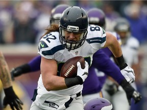 Luke Willson #82 of the Seattle Seahawks avoids a tackle by Chad Greenway #52 of the Minnesota Vikings during the first quarter on December 6, 2015 at TCF Bank Stadium in Minneapolis, Minnesota.