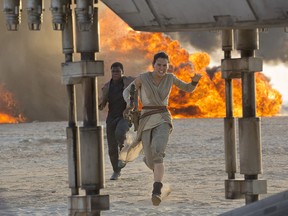 This photo provided by Disney/Lucasfilm shows Daisy Ridley, right, as Rey, and John Boyega as Finn, in a scene from the film, "Star Wars: The Force Awakens," directed by J.J. Abrams.