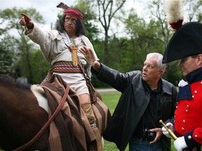 Sculptor Mark Williams instructs David Morris, posing as Chief Tecumseh, and Scott Finlay, playing the part of General Brock, at Paterson Park, May 17, 2014. Ward funds were used to commission a statue to the War of 1812 heroes.