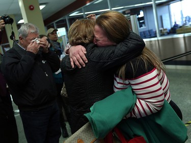 Hikemt Ashkar dries his eyes as his wife Salam Ashkar hugs their daughter Sohier Ashkar (right) after she arrived with her family in Windsor on Friday, Dec. 11, 2015. The Syrian family arrived from Lebanon after a stop over in Toronto.