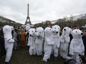 White bears costumed activists demonstrate near the Eiffel Tower, in Paris, Saturday, Dec.12, 2015 during the COP21, the United Nations Climate Change Conference. As organizers of the Paris climate talks presented what they hope is a final draft of the accord, protesters from environmental and human rights groups gather to call attention to populations threatened by rising seas and increasing droughts and floods.