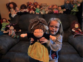Avah Toohey, 5, holds a Waldorf-style babydoo doll her mother Jennifer Toohey creates on her sewing machine.