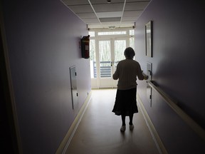 An unidentified elderly woman walks down the hall of a nursing home in this file photo.