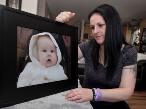 Jen Bois with portrait of her daughter Kylee Grace Cooper-Bois, 9 months old, who passed away in December 2014 just days before a scheduled liver transplant.