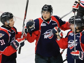 Windsor Spitfires Logan Brown, centre, glances at the scoreboard as teammate Mikhail Sergachev, left, and Brendan Lemieux celebrate a goal against Owen Sound Attack in OHL action from WFCU Centre Jan. 7, 2016.